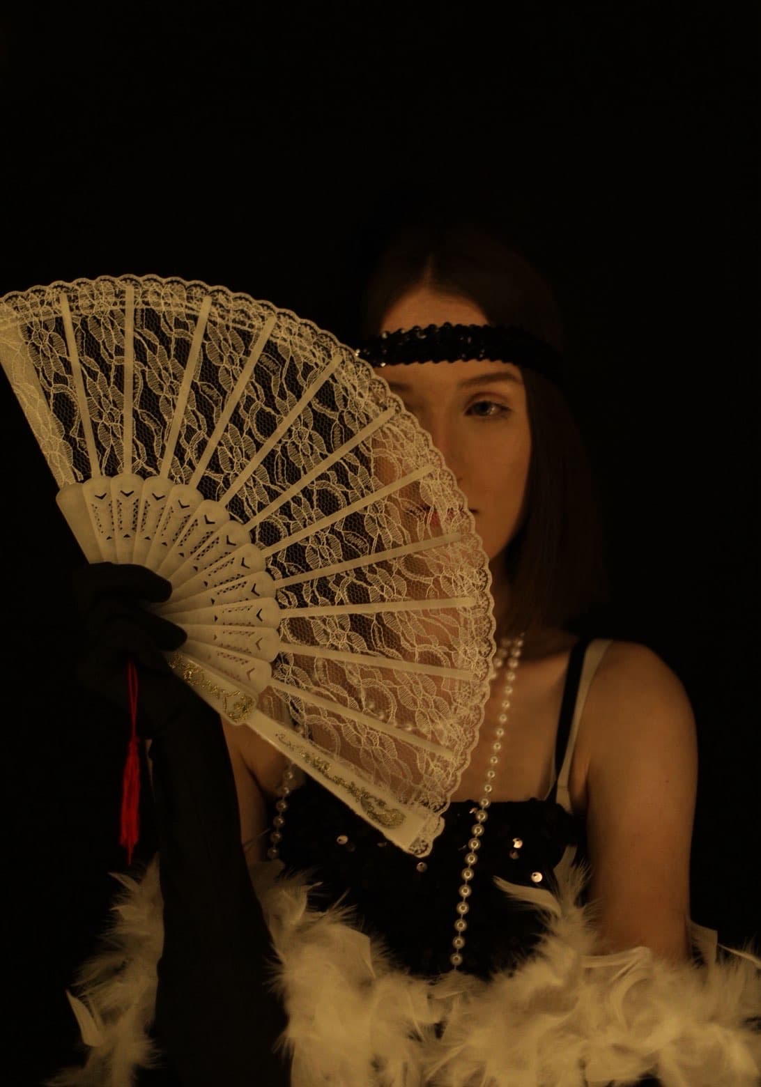 Low-key portrait with fan prop and warm light